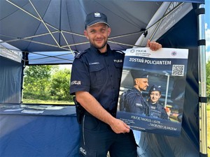 na zdjęciu widać policjanta z plakatem