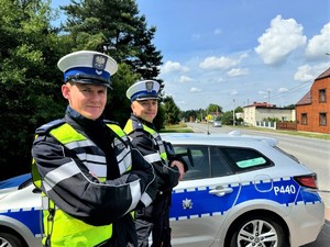 na zdjeciu widać dwóch policjantów przy radiowozie