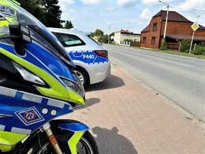 ba zdjeciu widać policyjny motocykl i radiowóz