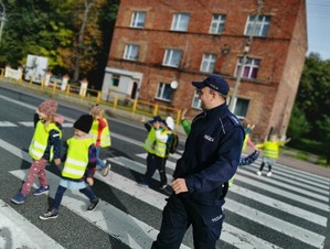 na zdjęciu widać policjanta i dzieci na przejściu dla pieszych