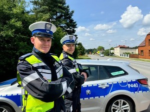 na zdjęciu widać dwóch policjantów i radiowóz