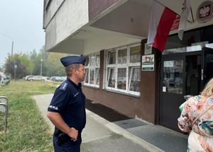 na zdjeciu widać policjanta przed szkołą