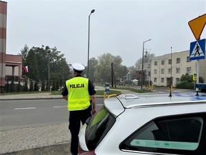 na zdjeciu widać policjanta i radiowóz przy szkole