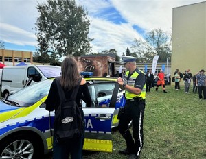 na zdjeciu widać policjanta przy radiowozie