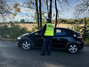 na zdjeciu widać policjanta i samochód