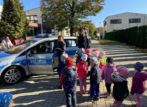 na zdjeciu widać dzieci, radiowóz i policjantów