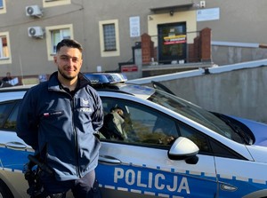 na zdjeciu widać policjanta i radiowóz