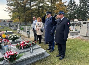 na zdjeciu widać mundurowych oraz cywili na cmentarzu