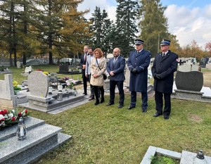 na zdjeciu widać mundurowych oraz cywili na cmentarzu