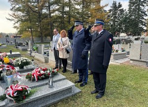 na zdjeciu widać mundurowych oraz cywili na cmentarzu