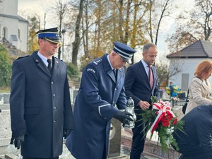 na zdjeciu widać mundurowych trzymających znicz