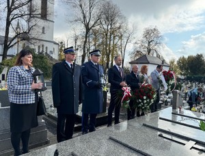 na zdjeciu widać mundurowych oraz cywili na cmentarzu