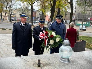 na zdjeciu widać mundurowych przed pomnikiem