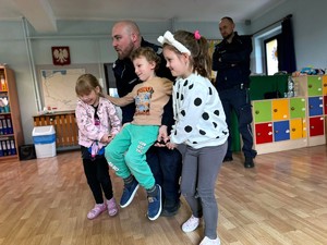 na zdjęciu widać dzieci i policjanta