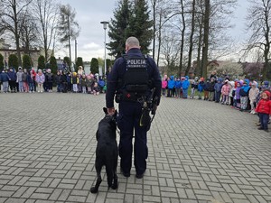 na zdjęciu widać policjanta, psa i dzieci