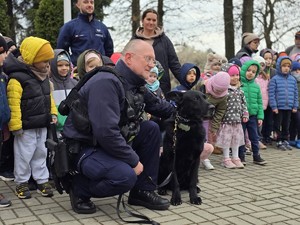 na zdjęciu widać policjanta, psa i dzieci