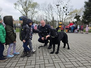 na zdjęciu widać policjanta, psa i dzieci