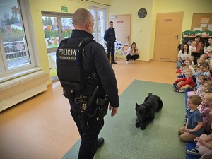 na zdjęciu widać policjantów, psa i dzieci