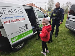 na zdjęciu widać policjanta, psa i dziewczynkę