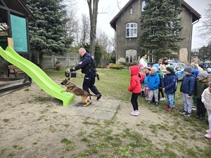 na zdjęciu widać policjanta, psa i dzieci