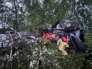 na zdjęciu widać samochody, strażaków i policjanta