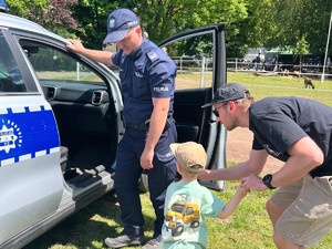 na zdjęciu widać policjanta, radiowóz i dziecko