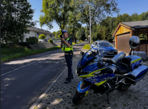 Zdjęcie przedstawia policjanta mierzącego prędkość