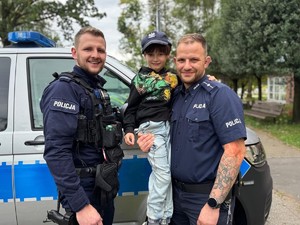 na zdjeciu widać policjantów i chłopca