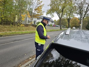 na zdjeciu widać policjanta przy samochodzie