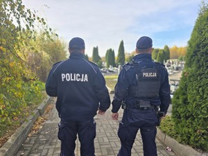 na zdjeciu widać policjantów przed cmentarzem