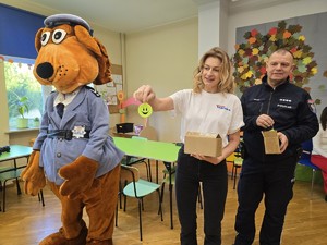 na zdjeciu widać policjanta i maskotkę