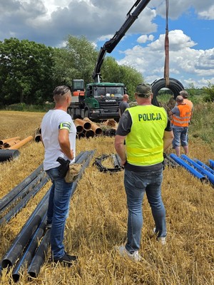 na zdjeciu widać materiały budowlane i policjantów