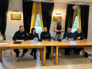 na zdjeciu widać policjanta i uczestników spotkania