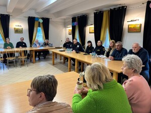 na zdjeciu widać policjanta i uczestników spotkania