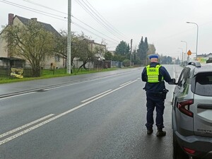 na zdjeciu widać policjanta przy samochodzie