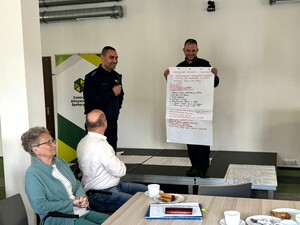 na zdjęciu widać policjanta i uczestników spotkania