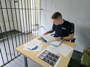 na zdjeciu widać policjanta przy stoliku