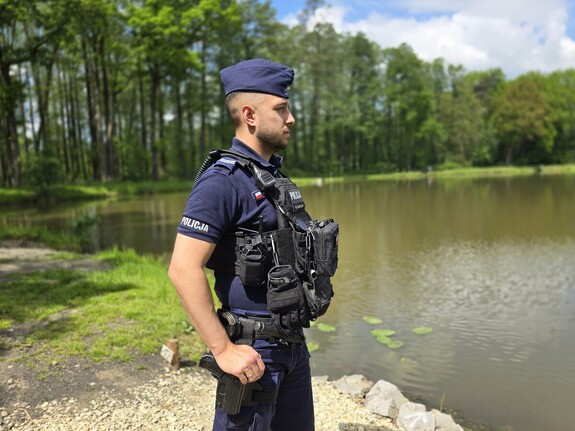 na zdjęciu widać policjanta nad stawem