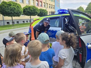 na zdjęciu widać policjanta, radiowóz i dzieci