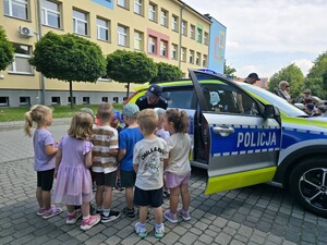 na zdjęciu widać policjanta, radiowóz i dzieci
