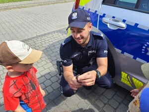 na zdjęciu widać policjanta, radiowóz i dzieci