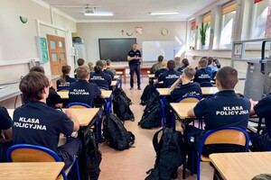 na zdjęciu widać uczniów i policjanta