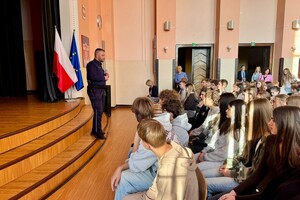na zdjeciu widać policjanta i uczniów