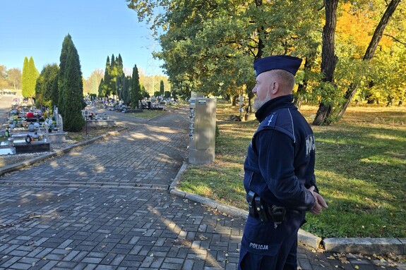 na zdjęciu widać policjanta ta przy cmentarzu